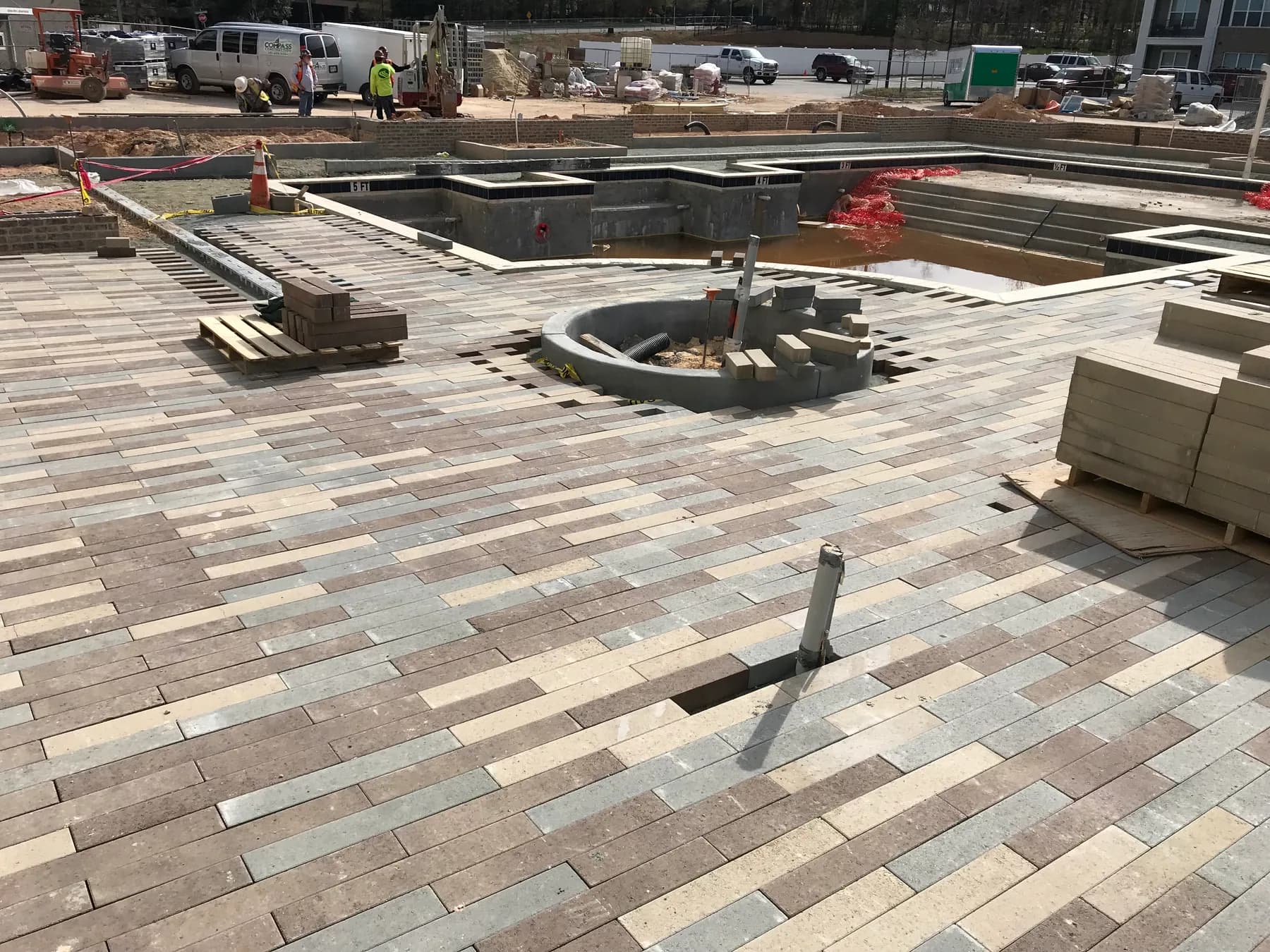 Completed commercial paver courtyard with planter edges and central hardscape feature
