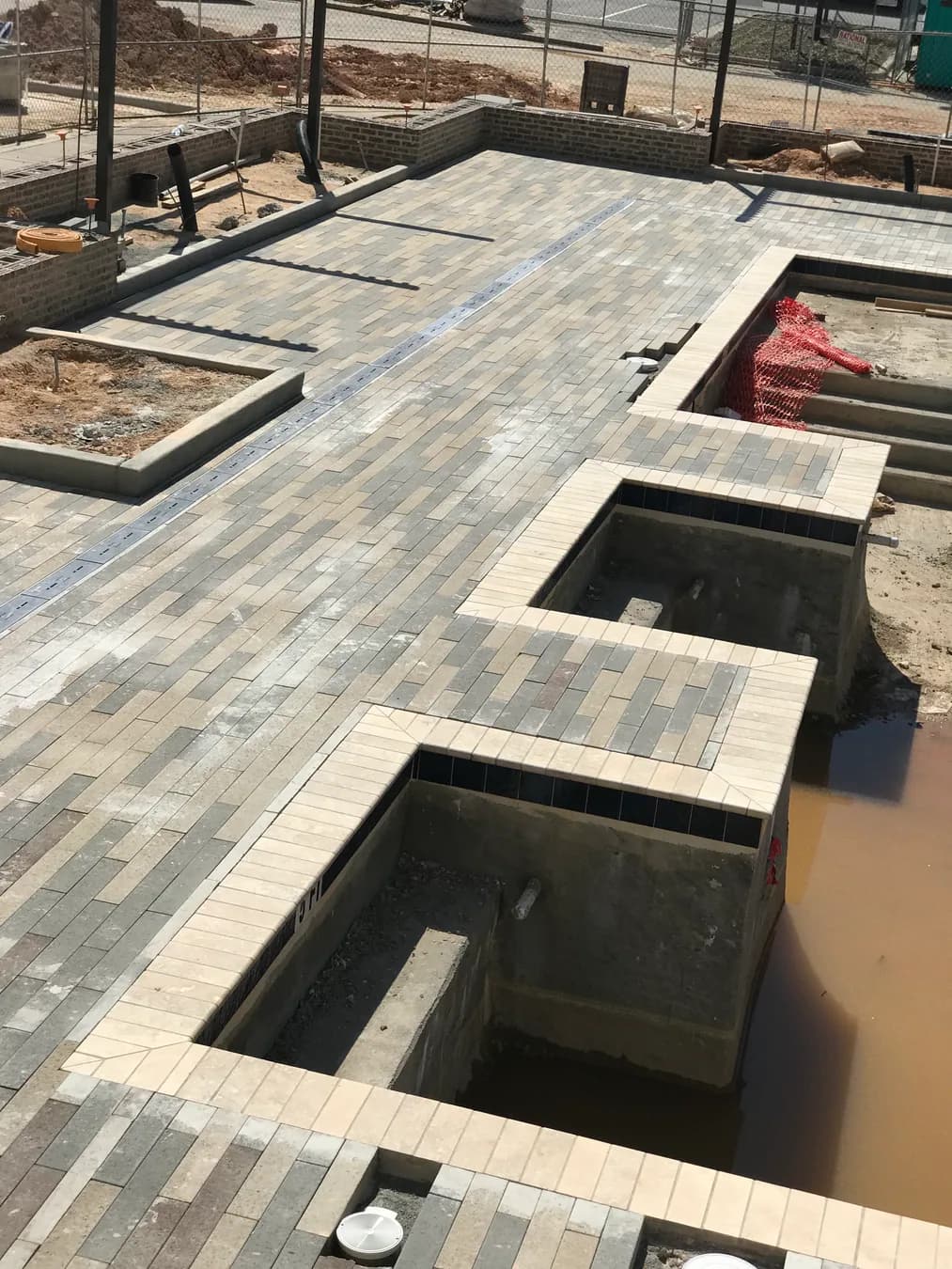 Commercial paver courtyard installation with hardscape layout and planting beds, view 2