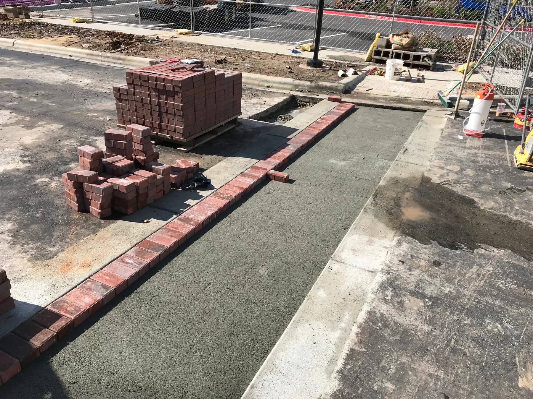 Commercial paver courtyard installation with hardscape layout and planting beds, view 5