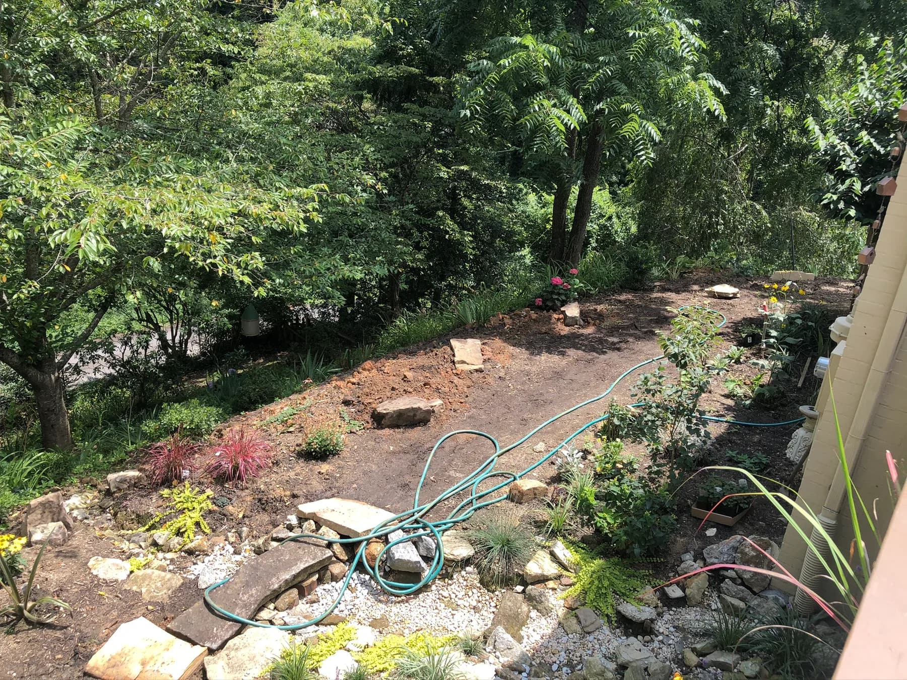 Planted garden edge and stone seating area before flagstone walk completion, view 1