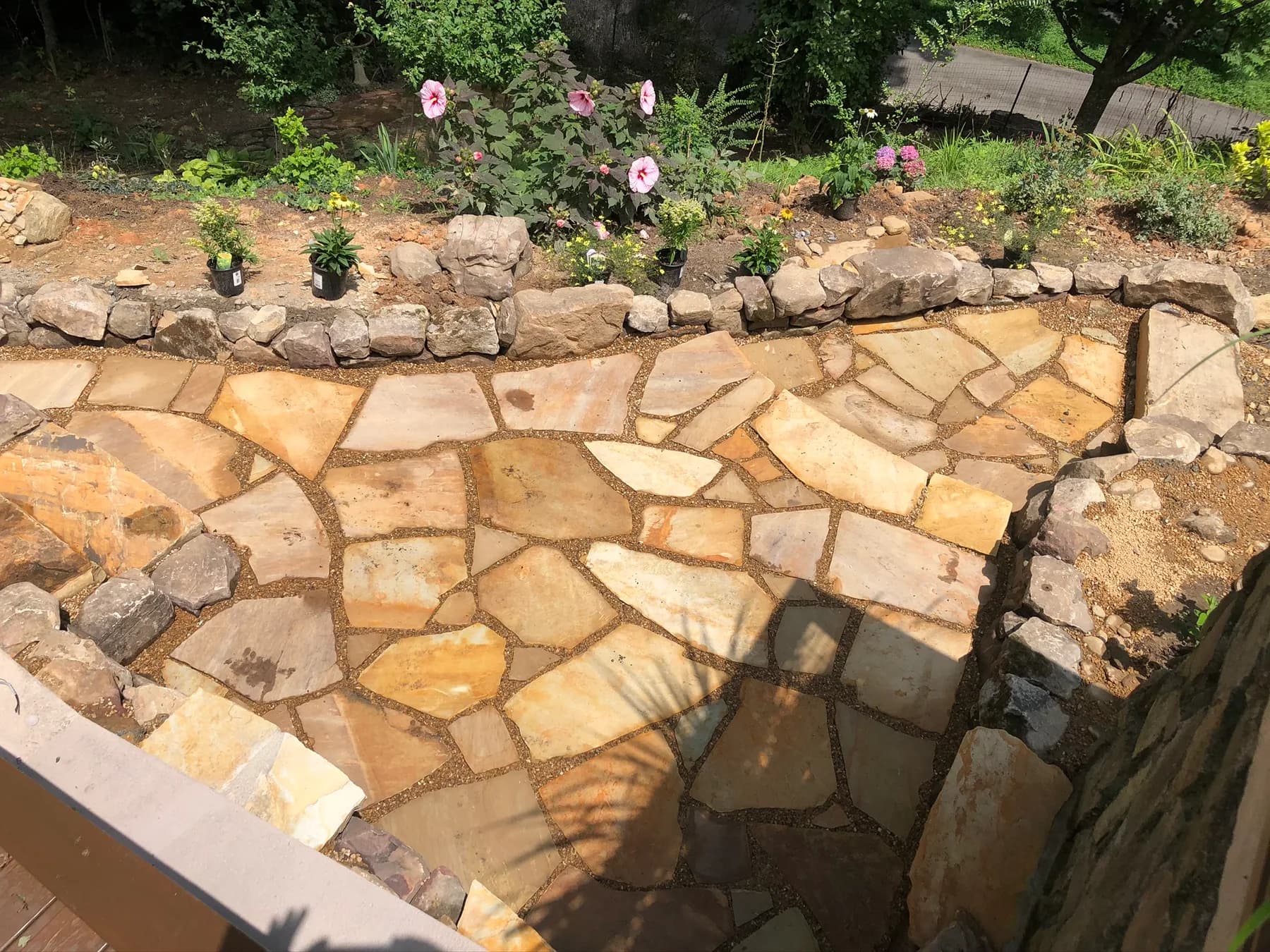 Finished flagstone walk, natural stone seating, and planting-edge transition, view 11