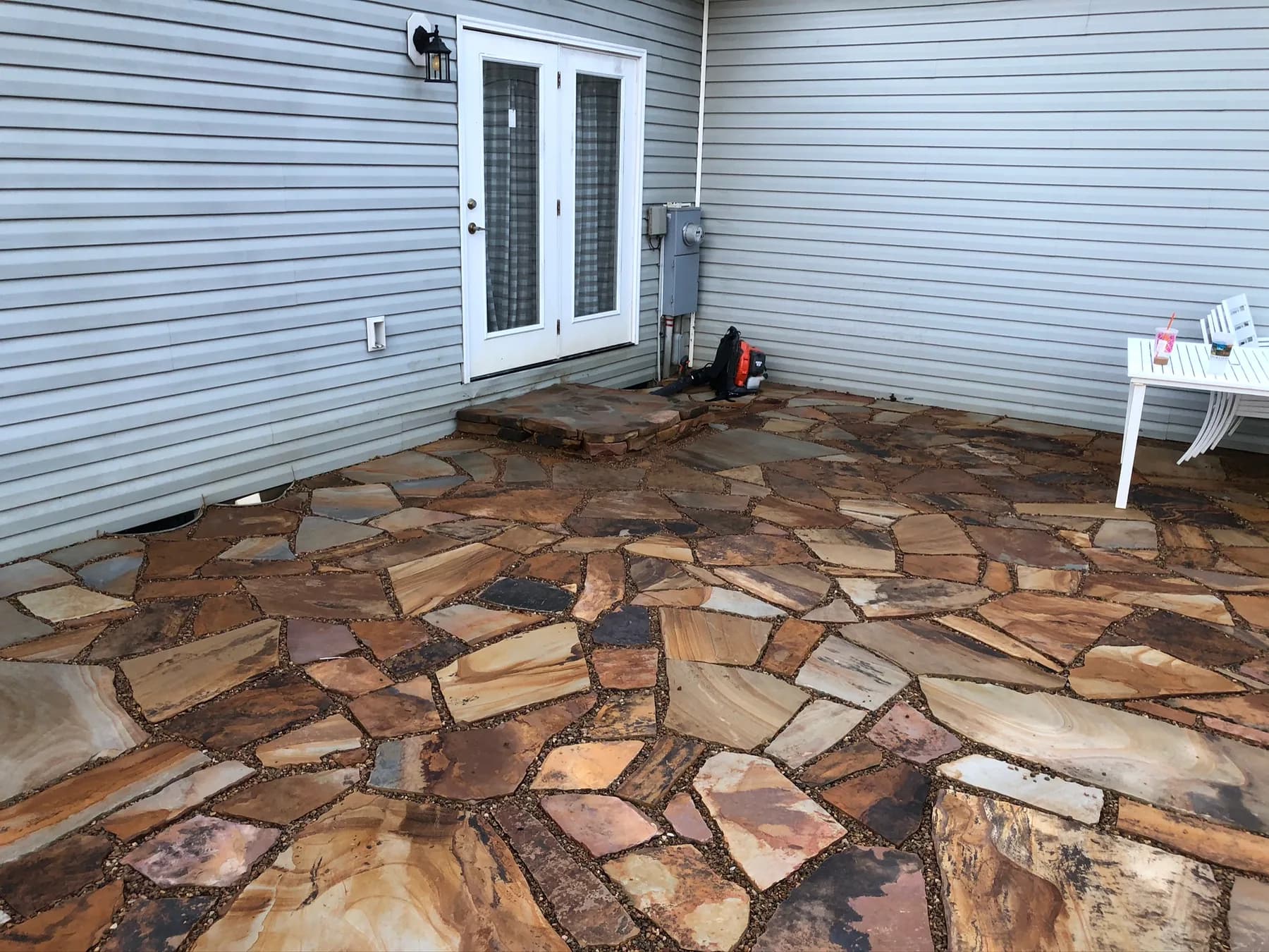 Finished natural stone patio surface and foundation-edge transition