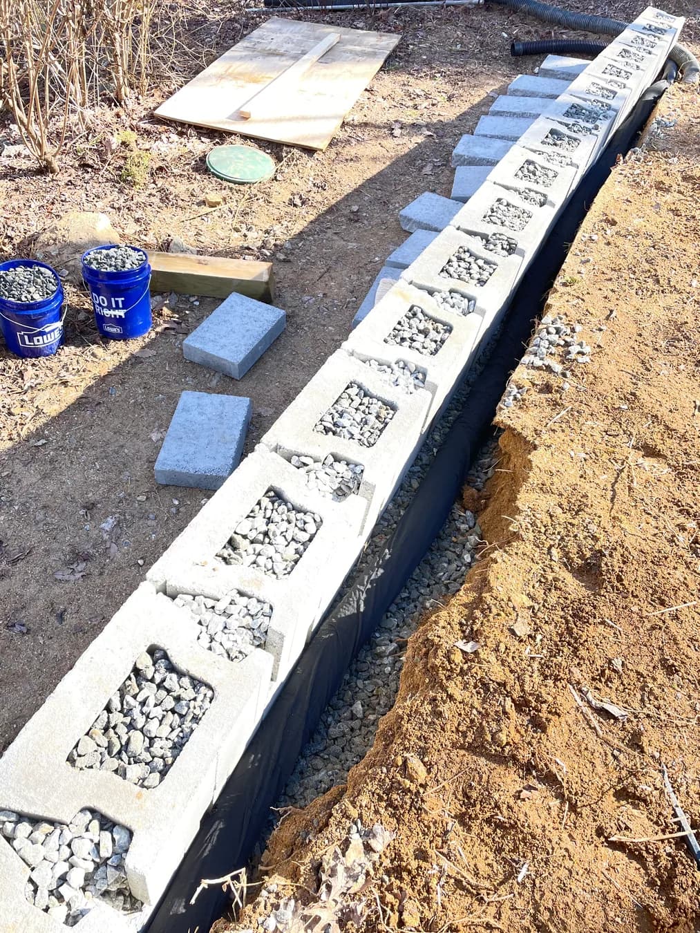 Retaining wall construction detail with block course and drainage stone, view 2