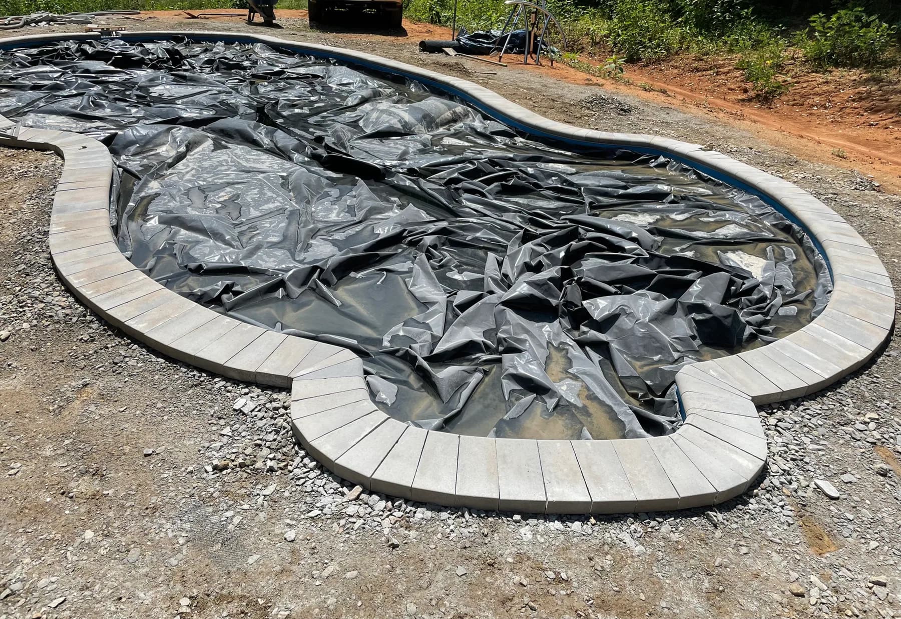 Curved pool coping and border pavers set before field pavers