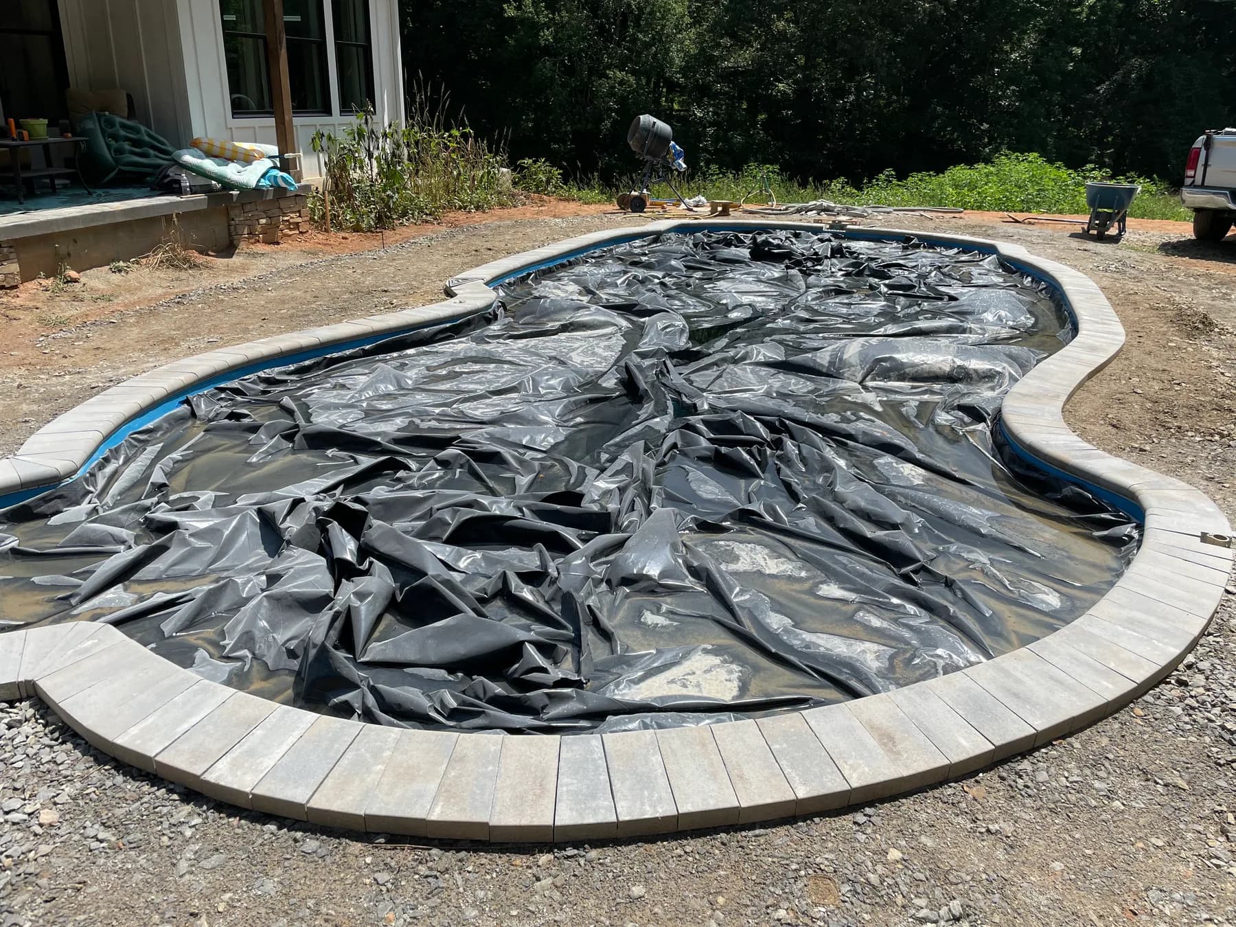 Poolside paver deck installation with border course and curved pool edge, view 5
