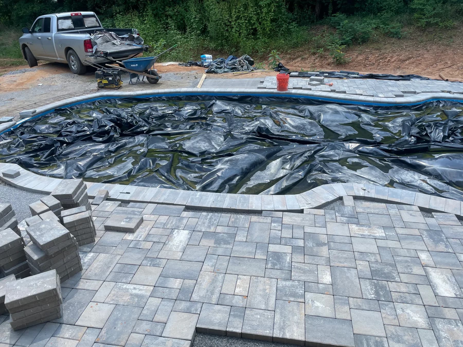 Poolside paver deck installation with border course and curved pool edge, view 7