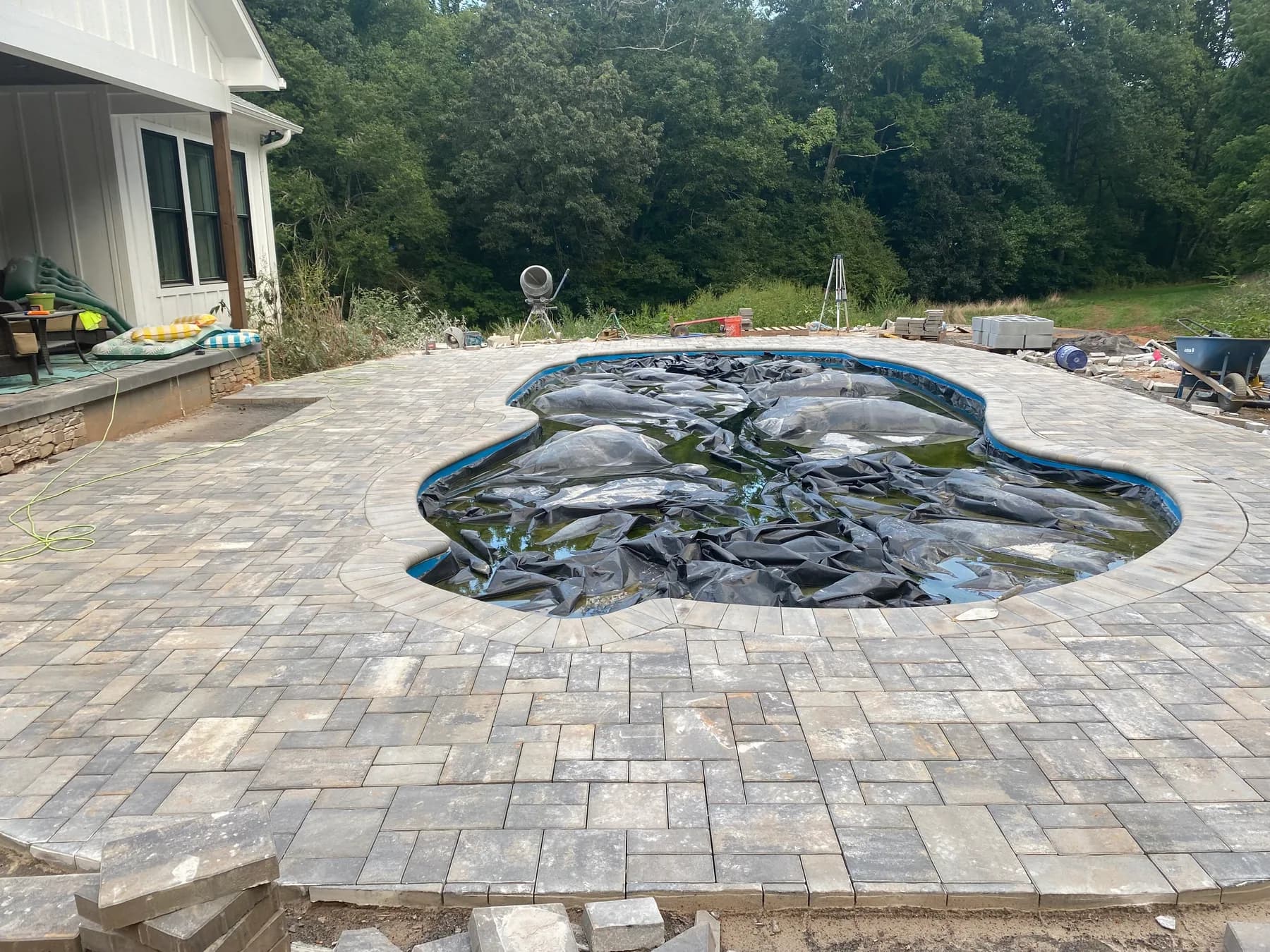 Poolside paver deck installation with border course and curved pool edge, view 10