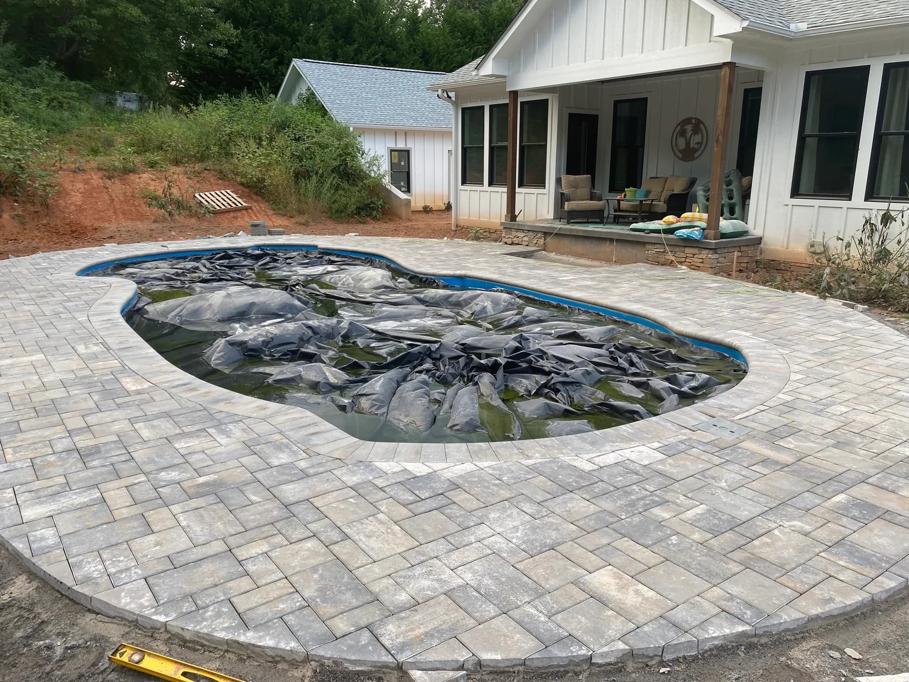 Poolside paver deck installation with border course and curved pool edge, view 11
