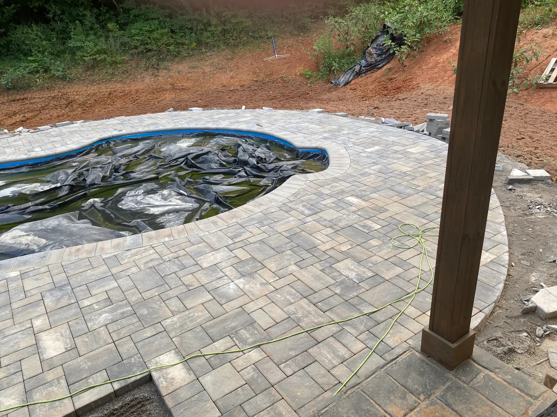 Poolside paver deck installation with border course and curved pool edge, view 12