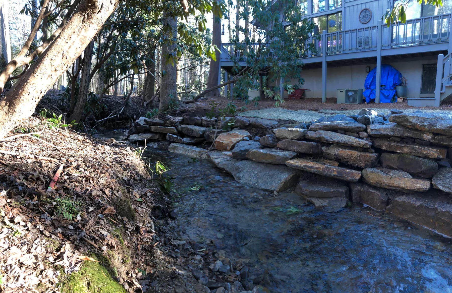 Natural stone placement along a riverbank edge for erosion control