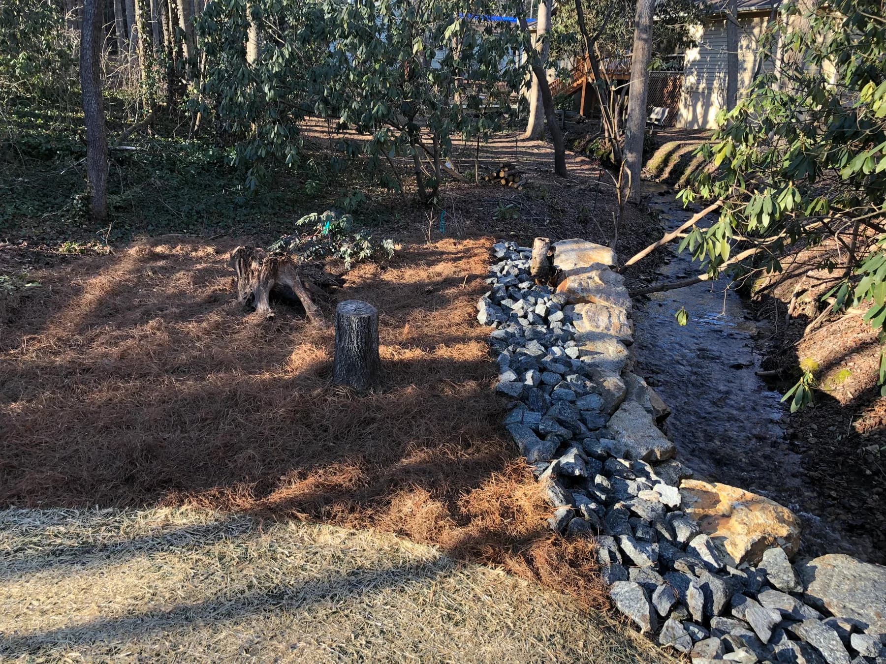Riverbank erosion-control stonework tying into the surrounding grade, view 4