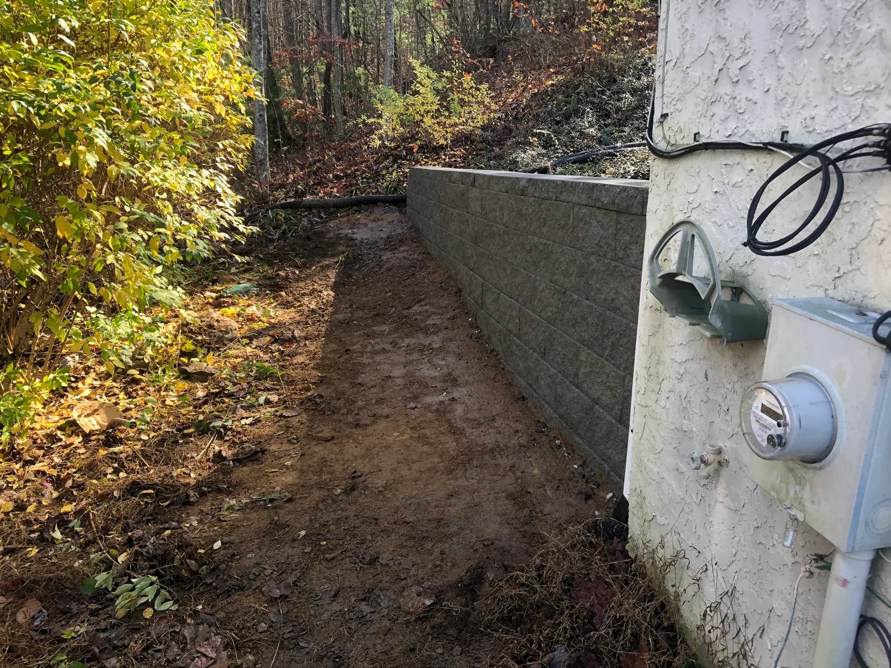 Finished segmental retaining wall along a wooded grade transition