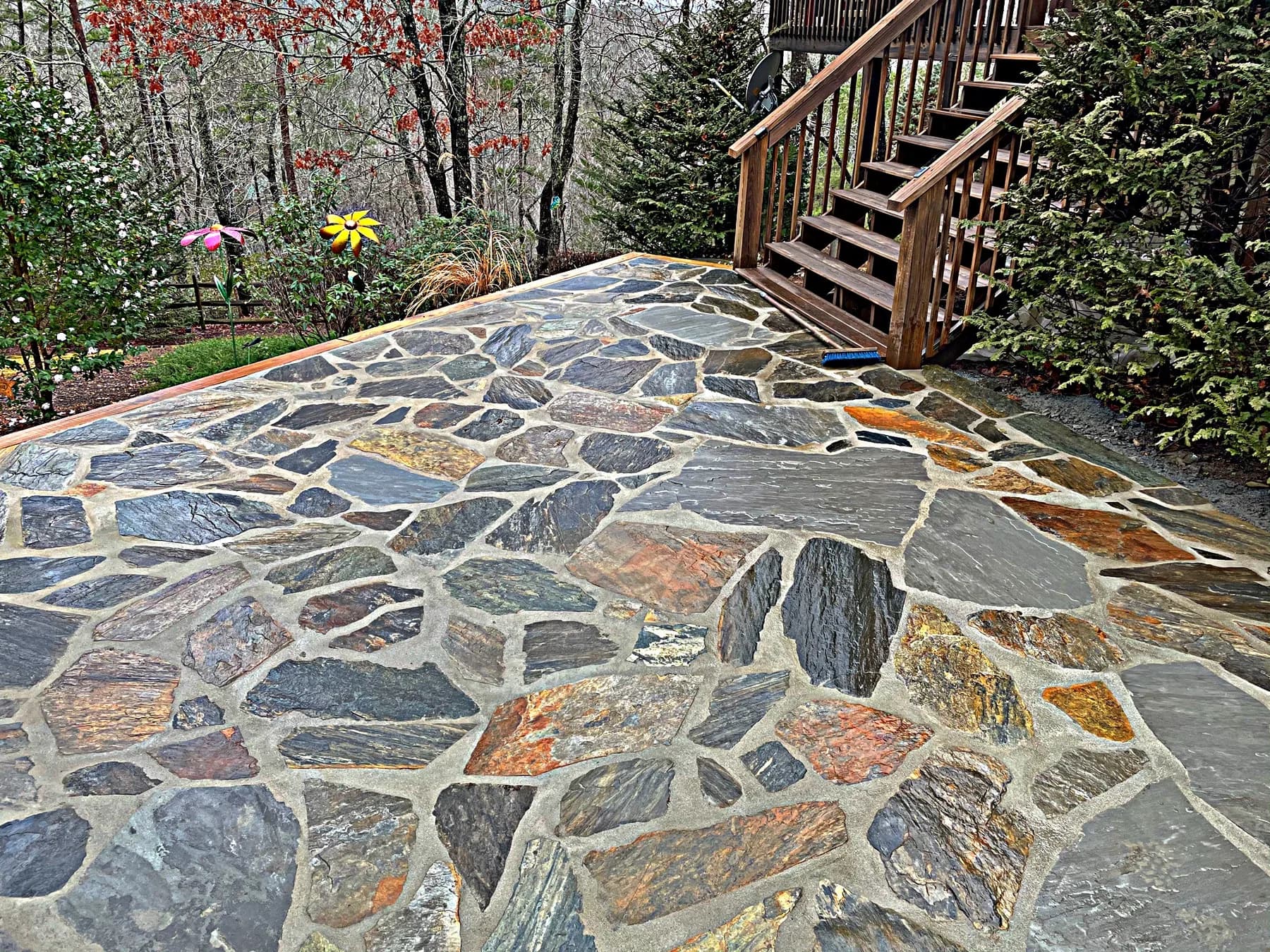 Finished natural stone patio with step and deck transition, view 4