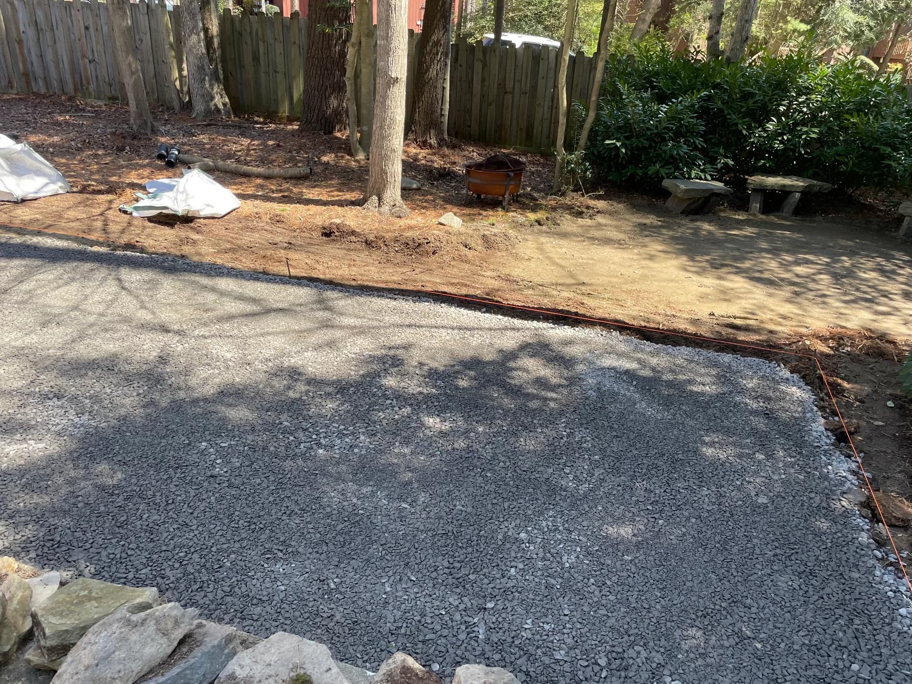 Aggregate base spread for woodland patio beside planted edge