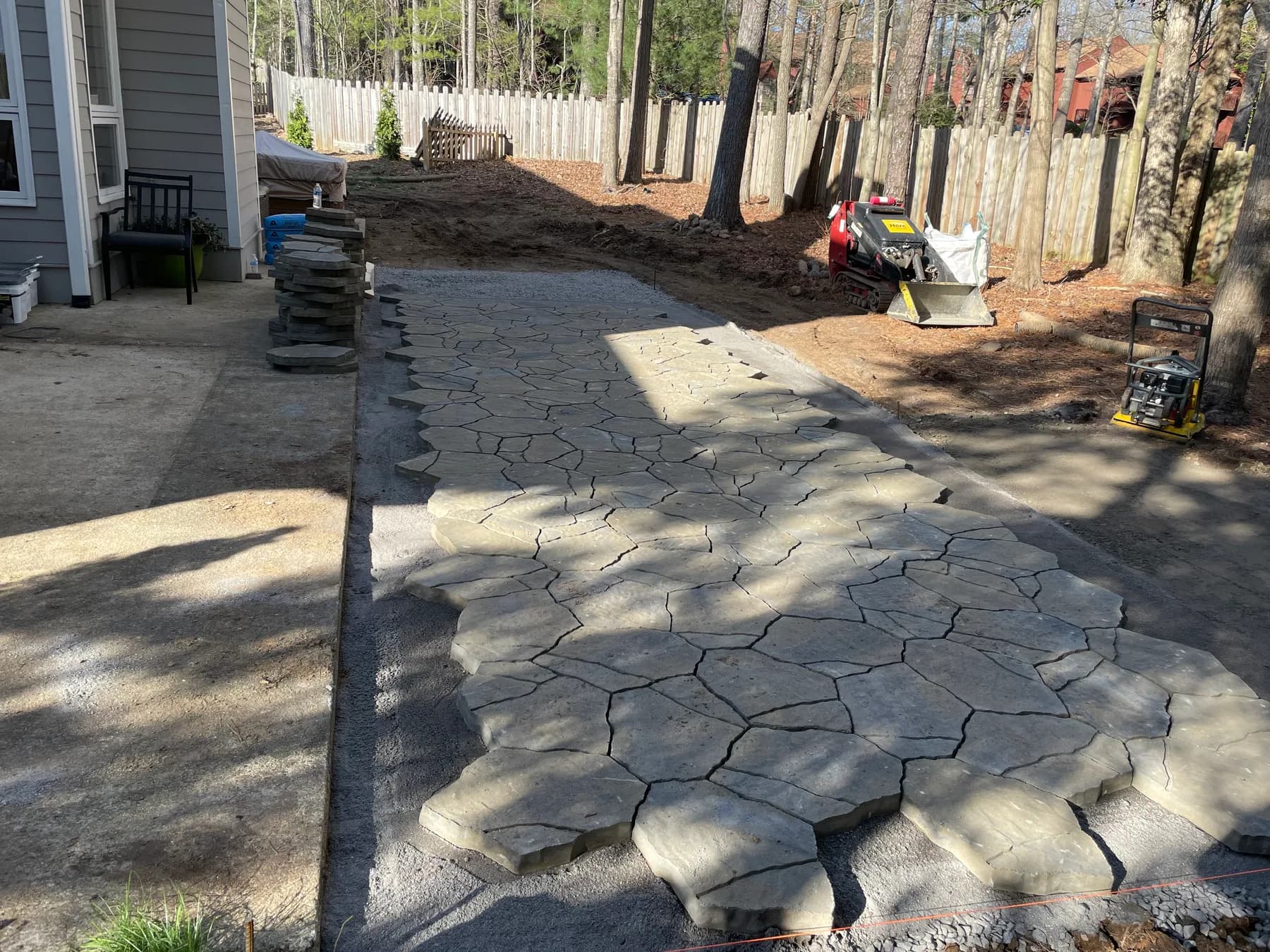 Paver field installation underway beside the house