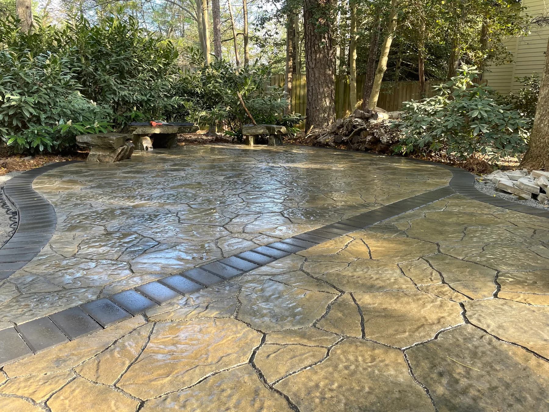 Completed woodland paver patio with curved border and stone seating
