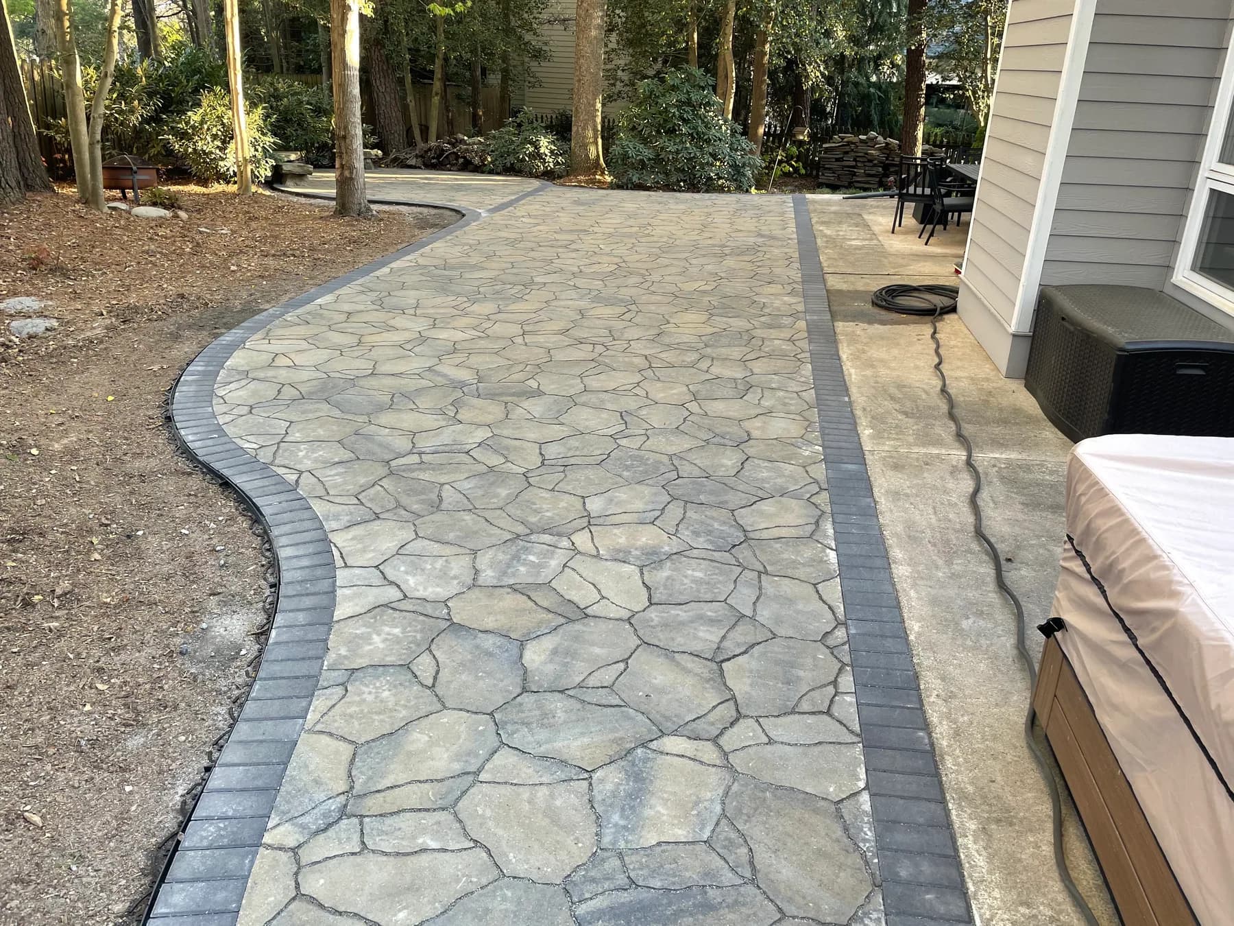 Woodland stone patio project with stone surfacing, border work, and outdoor seating area, view 17